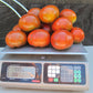 A fresh seven pound harvest of Paul Robeson Tomatoes, scale depicting weight 