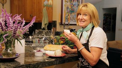 Woman preparing cheese at a kitchen counter
