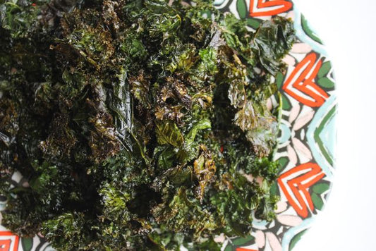 Delicious homemade baked kale chips served on a colorful patterned plate