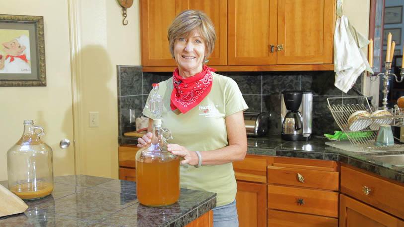 Woman holding a large jar of homemade cider