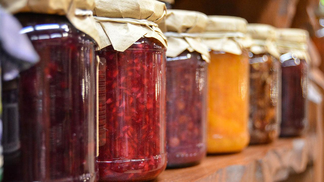 Row of glass jars filled with colorful preserves