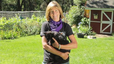 Gardener holding a black rabbit outdoors