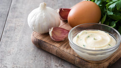 Bowl of creamy garlic aioli with garlic and egg