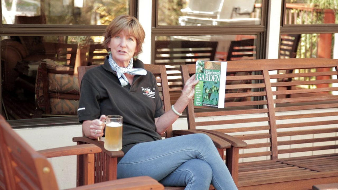 Woman holding a glass and bottle of home-brewed beer