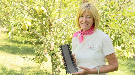 Gardener holding a beneficial-insect package in an orchard