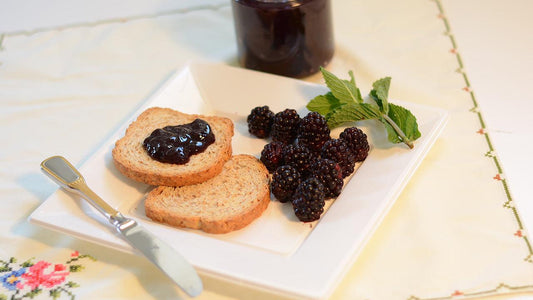 Blackberry jelly on toast beside fresh berries