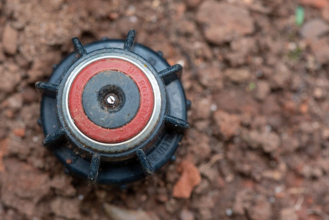 Garden irrigation sprinkler head set in brown soil