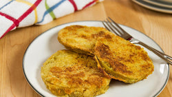 Three fried green tomato slices on a plate