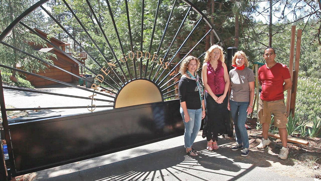 Four people standing beside a greenhouse