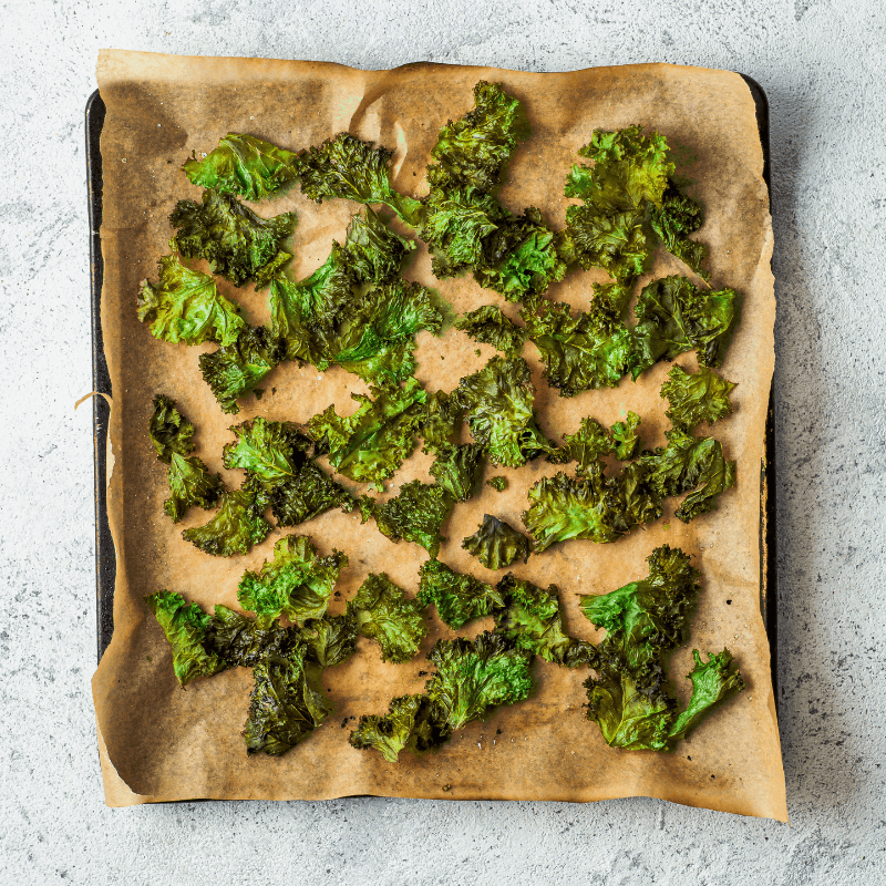 Baked kale chips on a lined tray