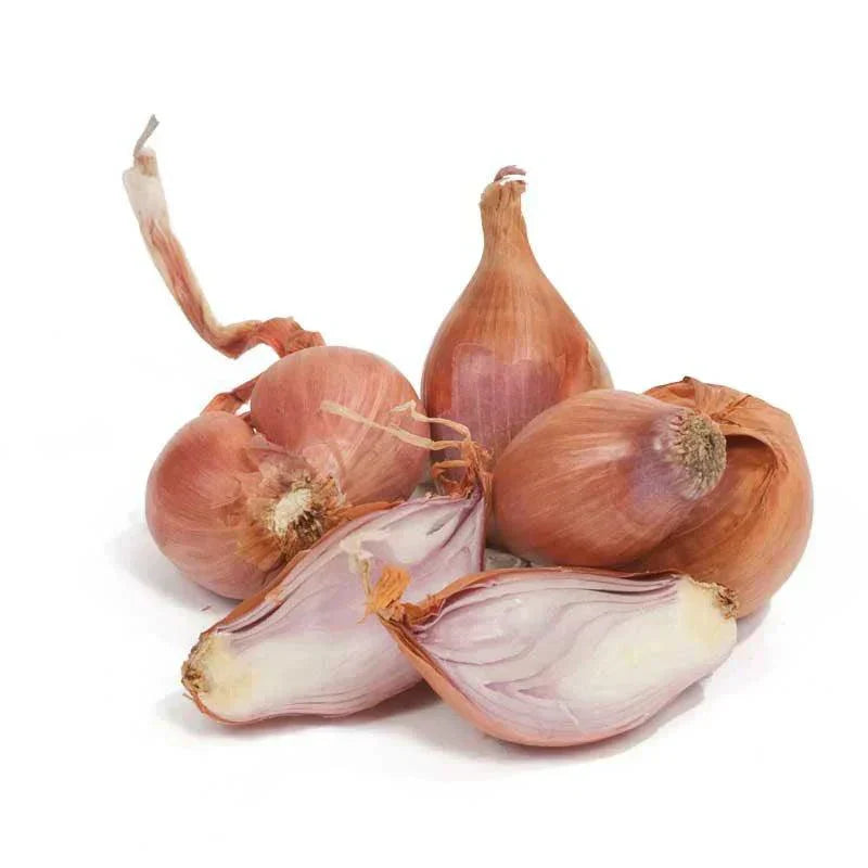 Whole and halved shallot bulbs on a white background