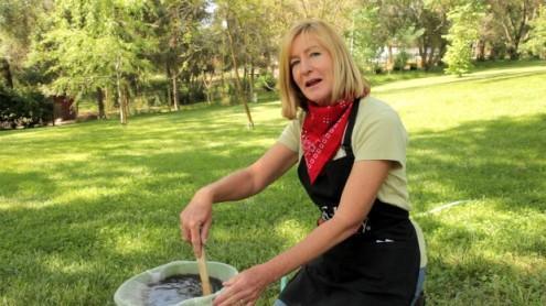 Woman stirring compost tea in a bucket outdoors