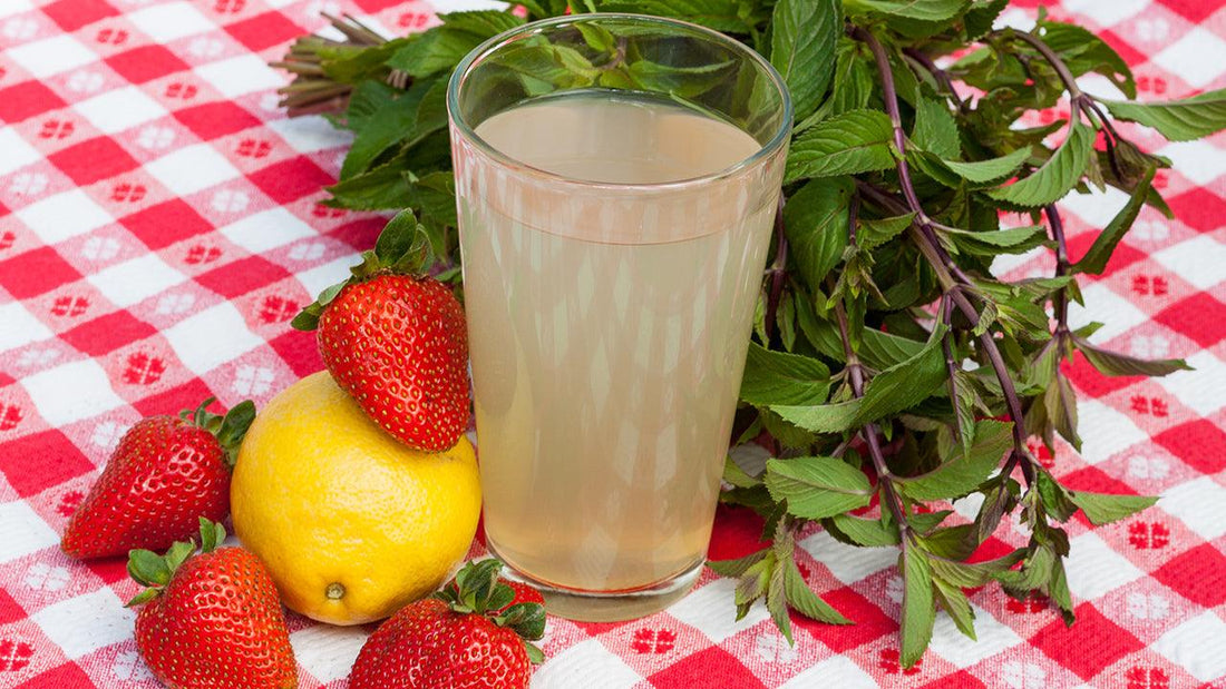 Glass of strawberry-mint lemonade with fresh fruit