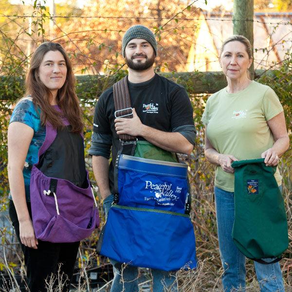 Three gardeners wearing harvesting aprons