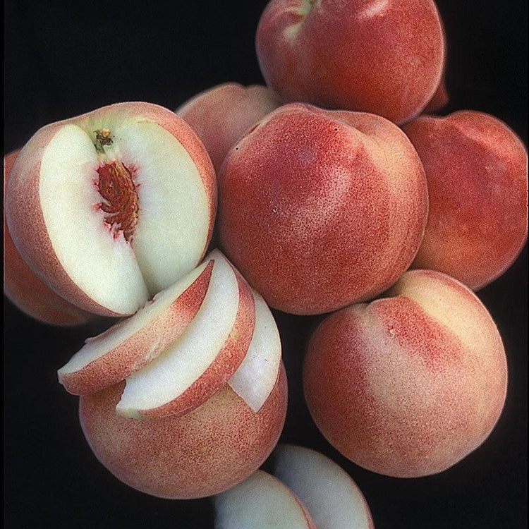 Whole and sliced white-fleshed peaches