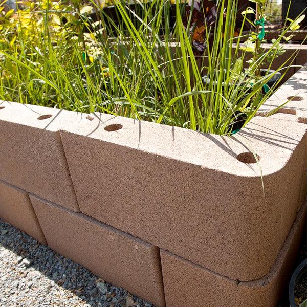Tall brown raised garden bed filled with grasses