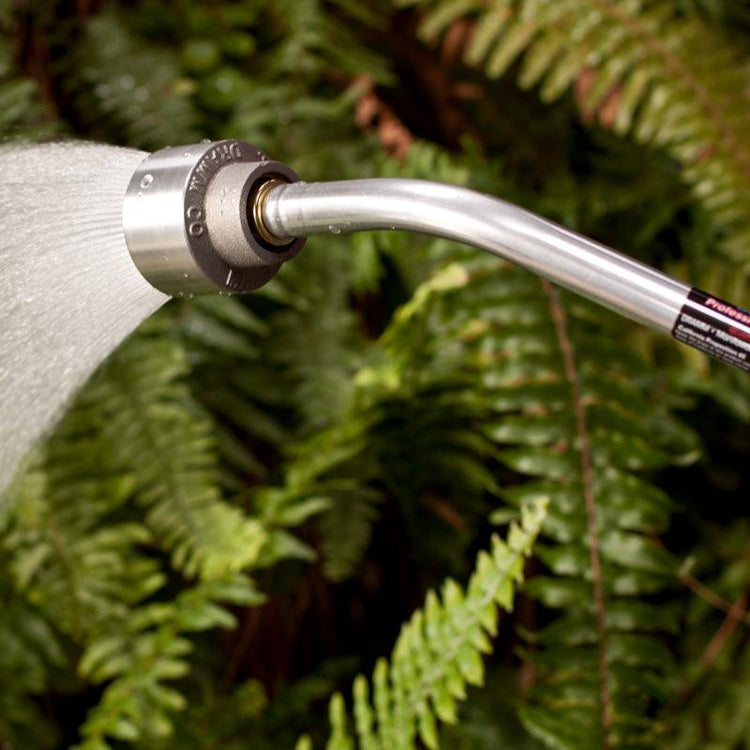 Metal watering wand spraying a broad fan of water