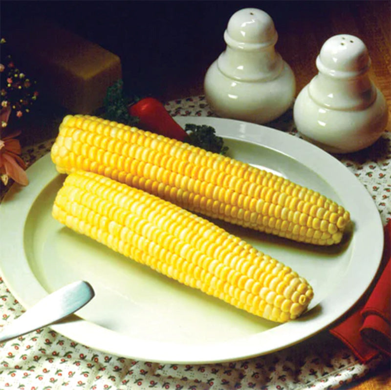 A plate presenting two ears of Honey Cream Corn on an artfully presented table