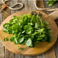Upland Cress resting on a circular cutting board, rustic display on wooden plank background 