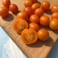 Cutting board full of Golden orange Honey Drop cherry tomatoes