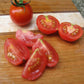 Halved and Quartered Fox Cherry Tomatoes resting on wooden cutting board